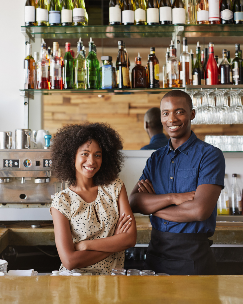 Two small business owners standing inside their business. 