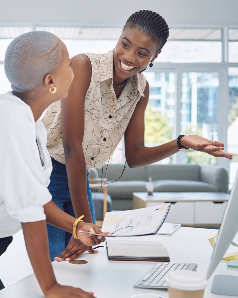 Two women in smiling conversation discussing business.