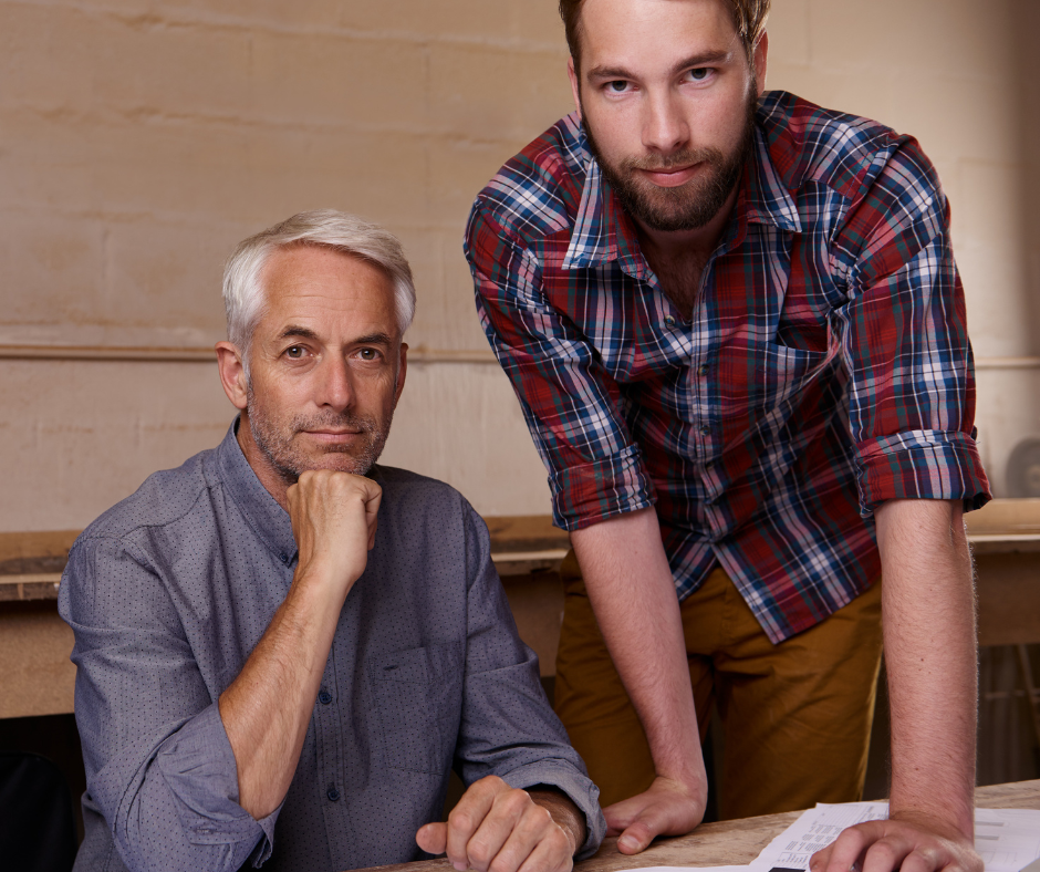 Two men looking forward as they work at a desk