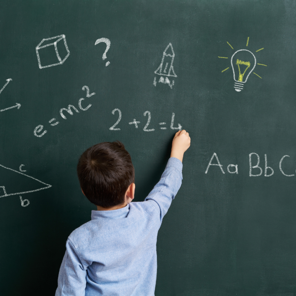 A child answering questions on a chalkboard